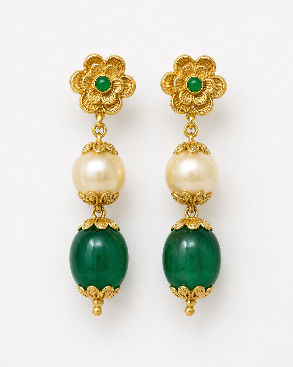 Gold earrings with green and pearl beads on a white background