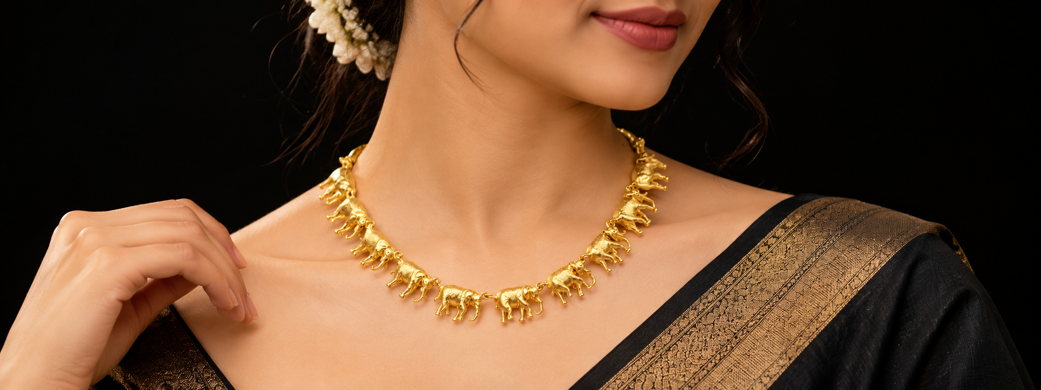 Golden elephant charm necklace worn with a silk saree
