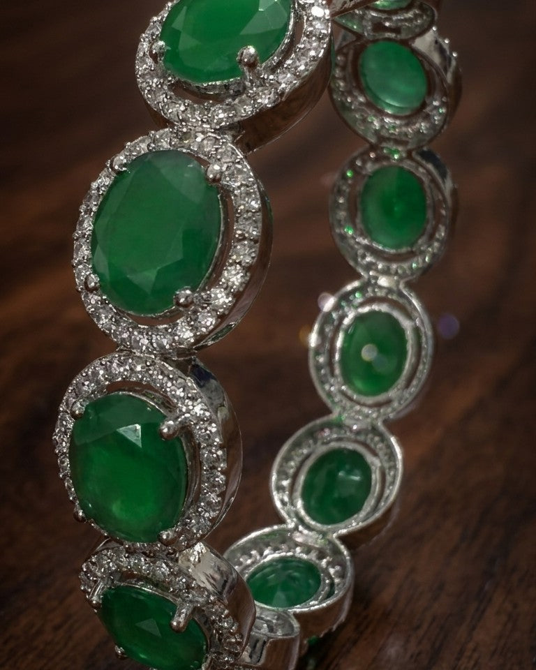 Bracelet with green gemstones and silver accents on a wooden surface
