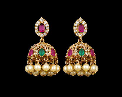 Pair of gold earrings with pearls and gemstones on a black background