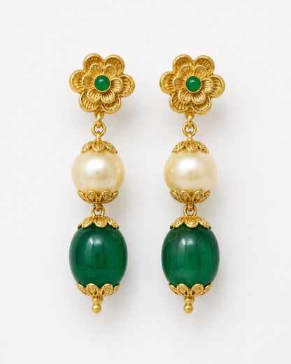 Gold earrings with green and pearl beads on a white background