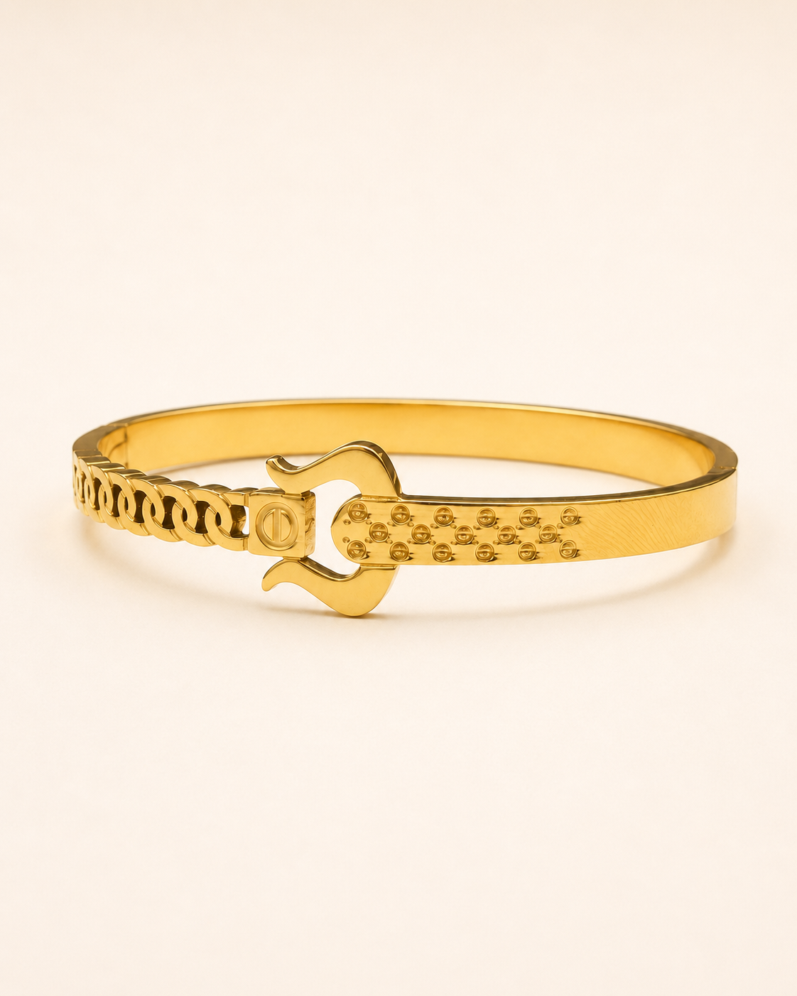 A gold-plated bangle bracelet featuring a central lock pick design and textured patterns on its ends, set against a plain off-white background.
