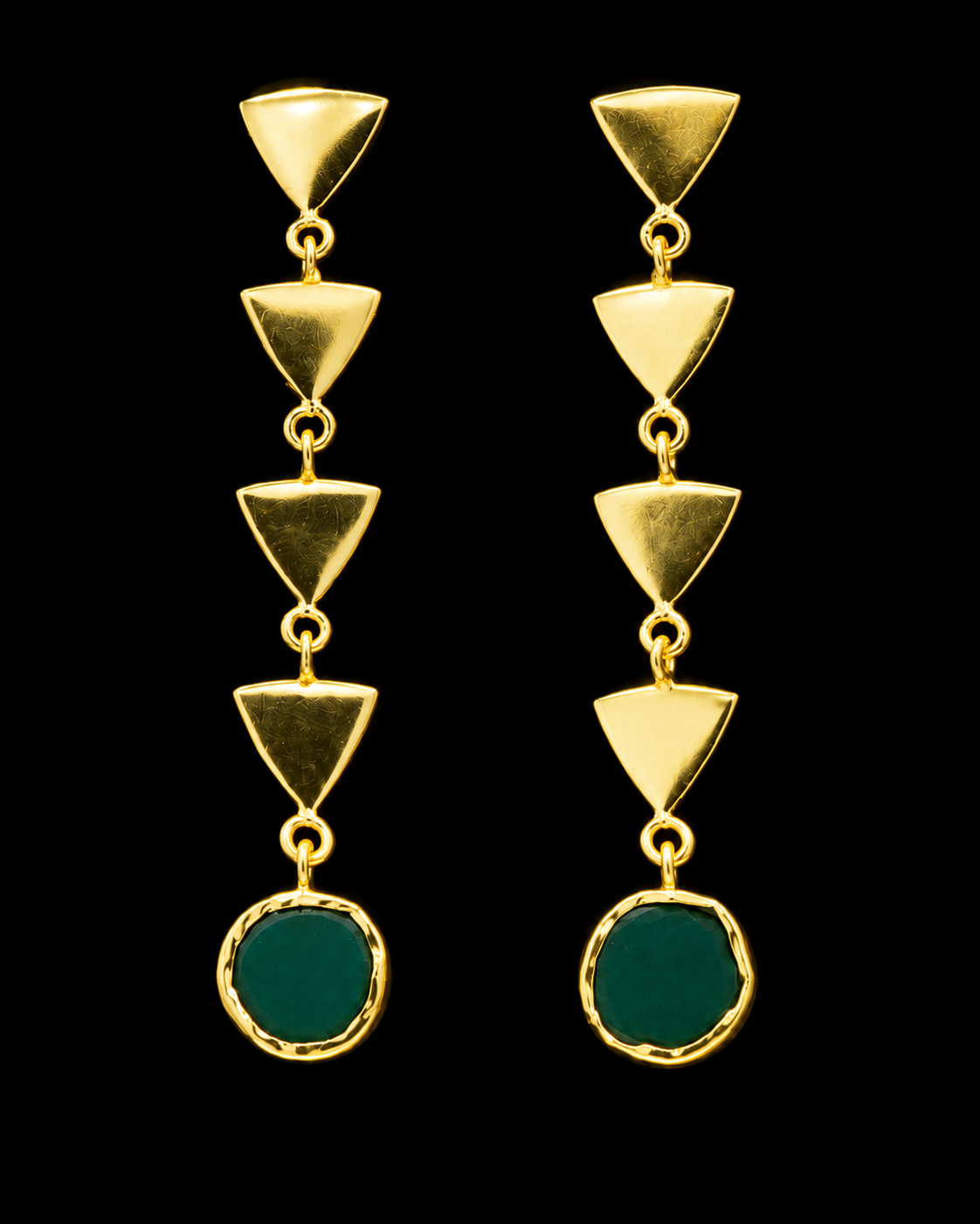 A pair of gold dangle earrings with five stacked triangular gold charms and a round green stone at the bottom, set against a solid black background.