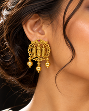 Woman in profile wearing gold Ram Durbar coin earrings
