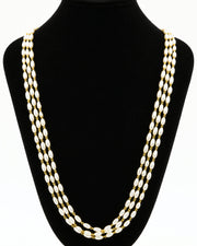 A gold-toned multi-strand chain necklace displayed on a black velvet jewellery bust against a plain white background.