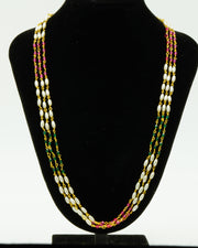 Long multi layer pearl, ruby and green stone necklace displayed on a black bust