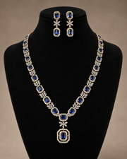 White CZ necklace with a dark green pendant and matching earrings on a black bust