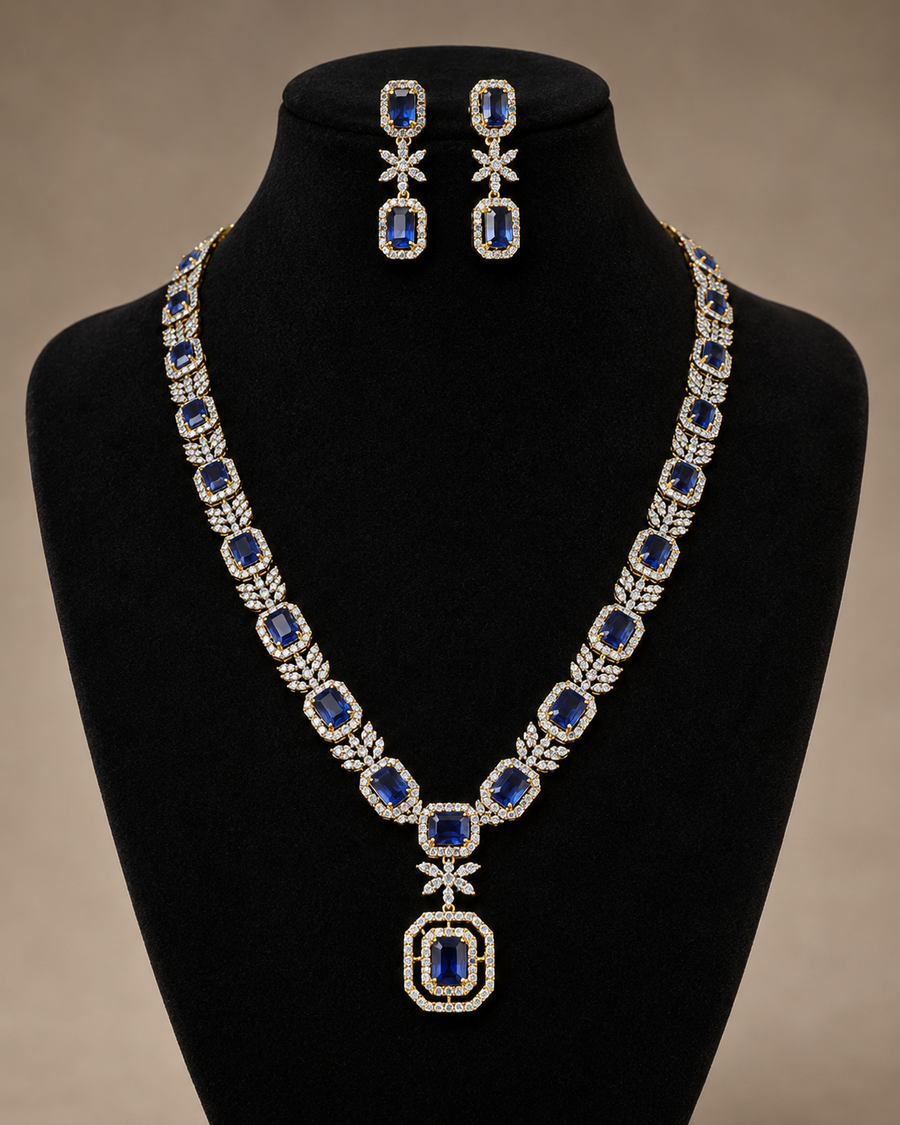 White CZ necklace with a dark green pendant and matching earrings on a black bust