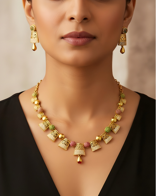 Gold necklace and earrings on a model with a neutral background