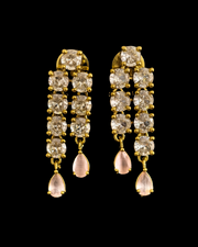 Long white CZ earrings with teardrop pearl drops on a black background
